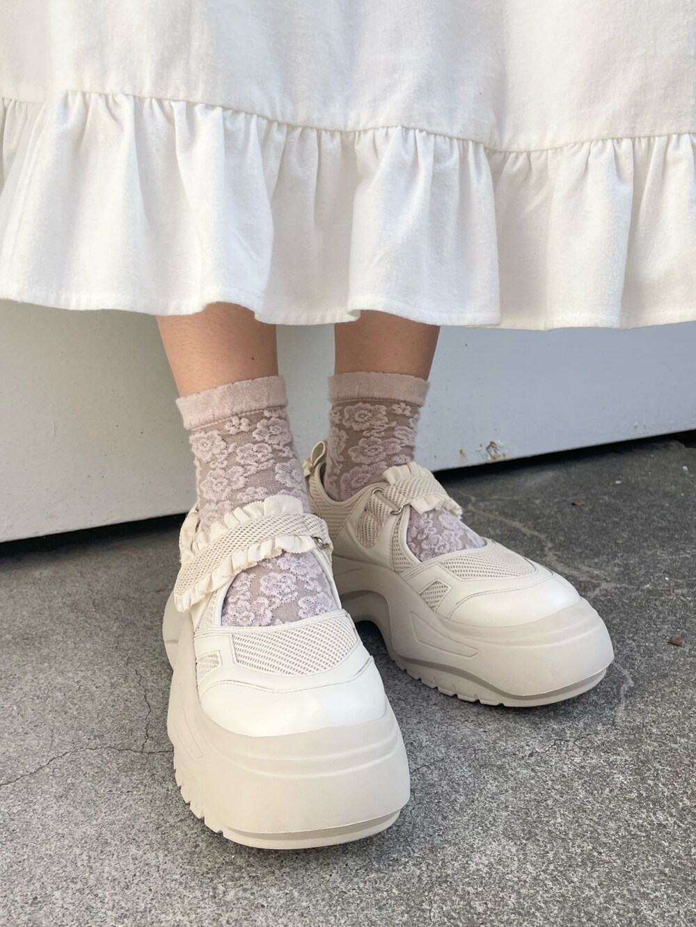 ホワイト系のダウンジャケット/コート、ホワイト系のワンピース、ホワイト系のスニーカーを着用したレディースの冬コーディネートの10枚目の写真