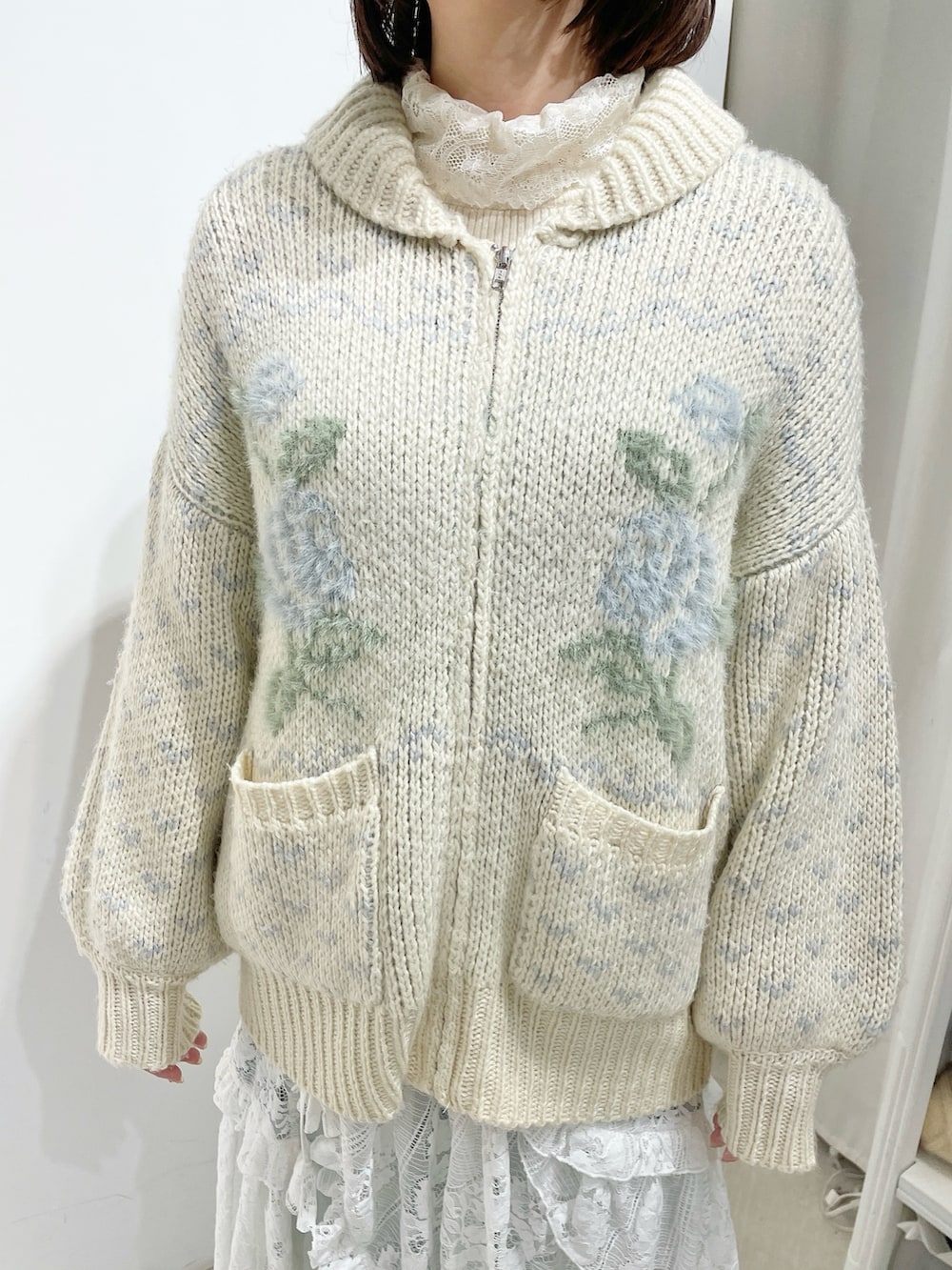 ホワイト系のニット/セーター、ブルー系のデニムパンツ、ホワイト系のスカートを着用したレディースの秋コーディネートの5枚目の写真