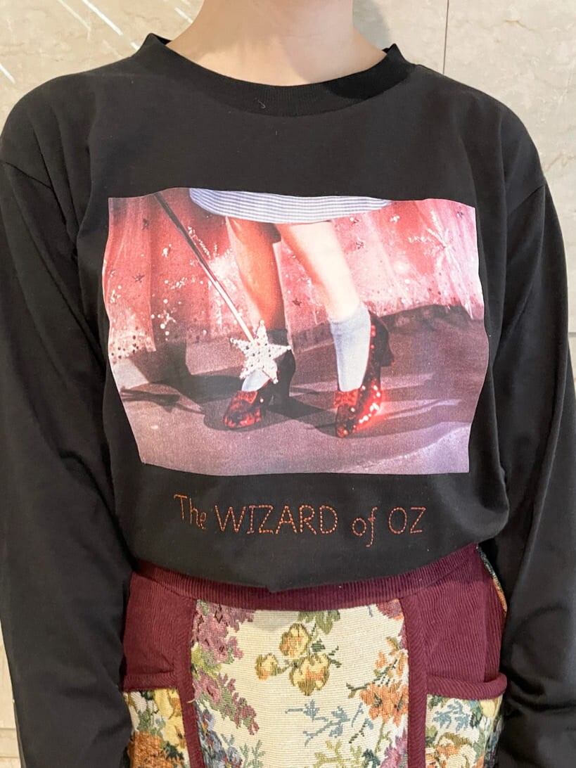 ブラック系のTシャツ/カットソー、レッド系のスカート、ブラック系のスニーカーを着用したレディースの秋コーディネートの4枚目の写真