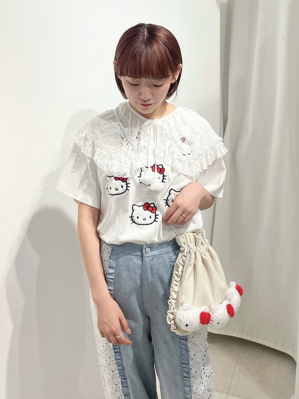 ブルー系のデニムパンツ、ホワイト系のスニーカー、ホワイト系のショルダーバッグを着用したレディースの春コーディネートの5枚目の写真
