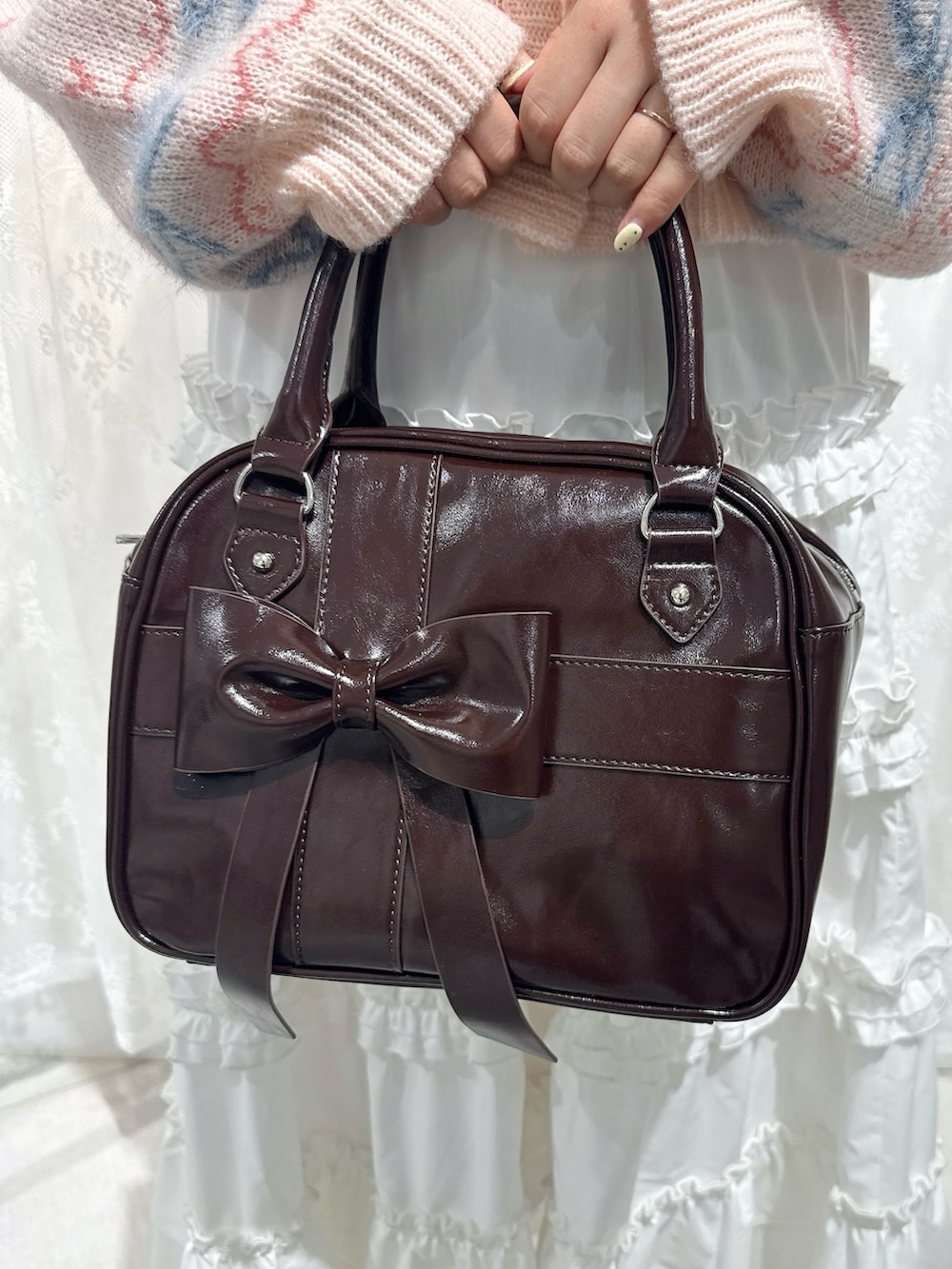 ピンク系のカーディガン/ボレロ、ホワイト系のスカート、ブラウン系のハンドバッグを着用したレディースの夏コーディネートの7枚目の写真