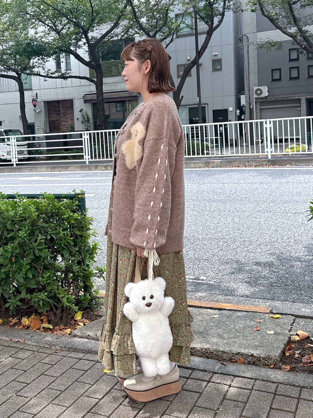 ホワイト系のニット/セーター、グリーン系のワンピース、ホワイト系のバレエシューズを着用したレディースの秋コーディネートの3枚目の写真