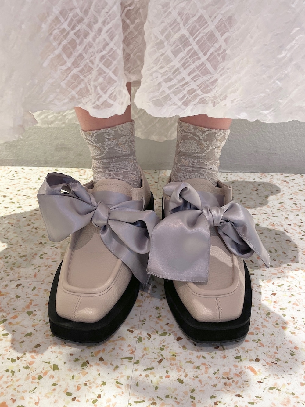 ホワイト系のスカート、ホワイト系のモカシン/デッキシューズ、レッド系のTシャツ/カットソーを着用したレディースの冬コーディネートの5枚目の写真