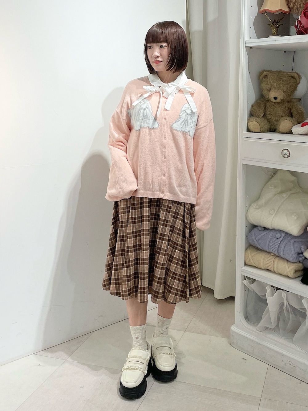 ホワイト系のシャツ/ブラウス、ピンク系のカーディガン/ボレロ、ブラウン系のスカートを着用したレディースの秋コーディネートの2枚目の写真