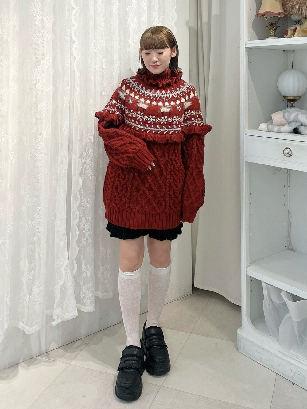 レッド系のニット/セーター、ブラック系のスウェットパンツ、ブラック系のローファーを着用したレディースの秋コーディネートの2枚目の写真