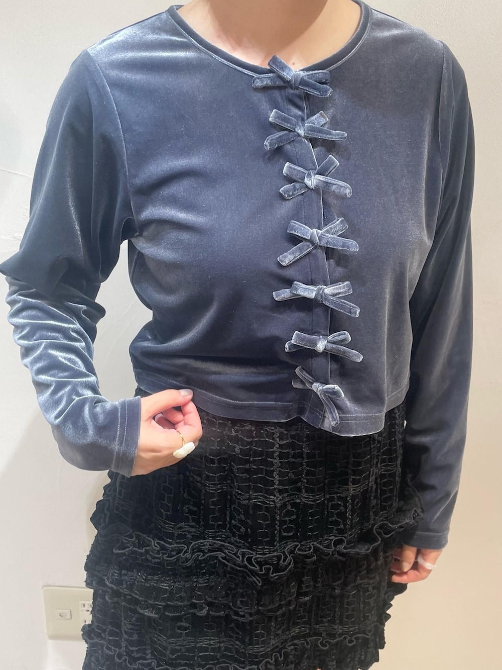 ブラック系のスカート、ブルー系のカーディガン/ボレロ、ブラック系のブーツを着用したレディースの冬コーディネートの5枚目の写真