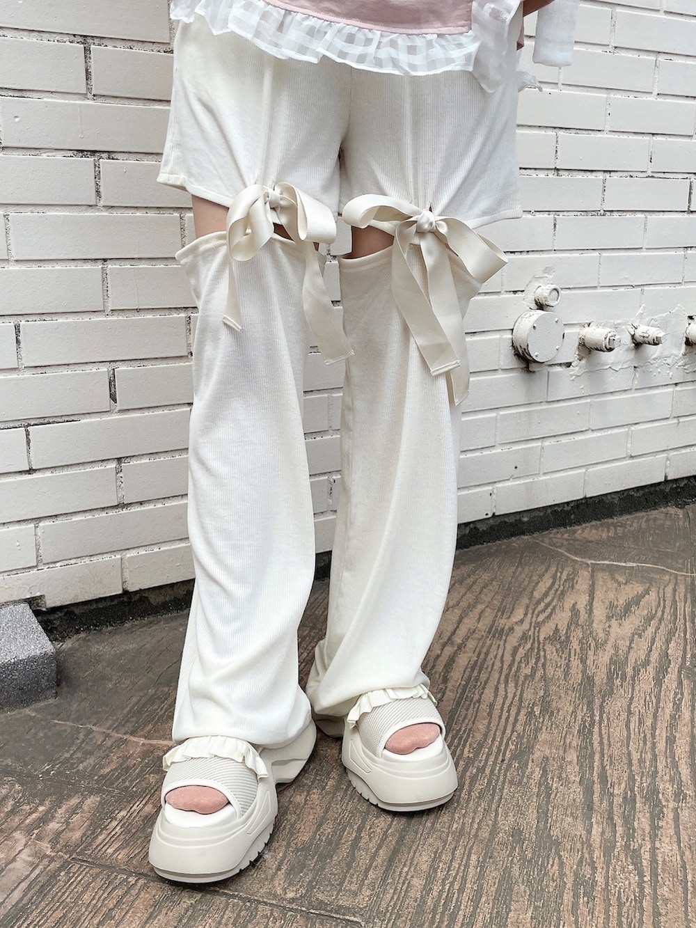 ピンク系のTシャツ/カットソー、ホワイト系のその他パンツ、ホワイト系のサンダルを着用したレディースの春コーディネートの7枚目の写真
