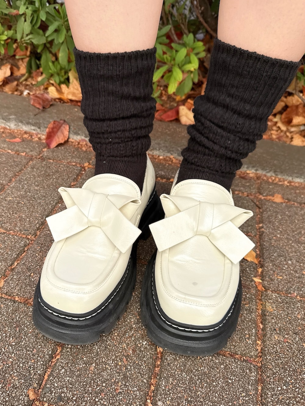 ピンク系のニット/セーター、グレー系のショルダーバッグ、ブラック系のスカートを着用したレディースの冬コーディネートの7枚目の写真