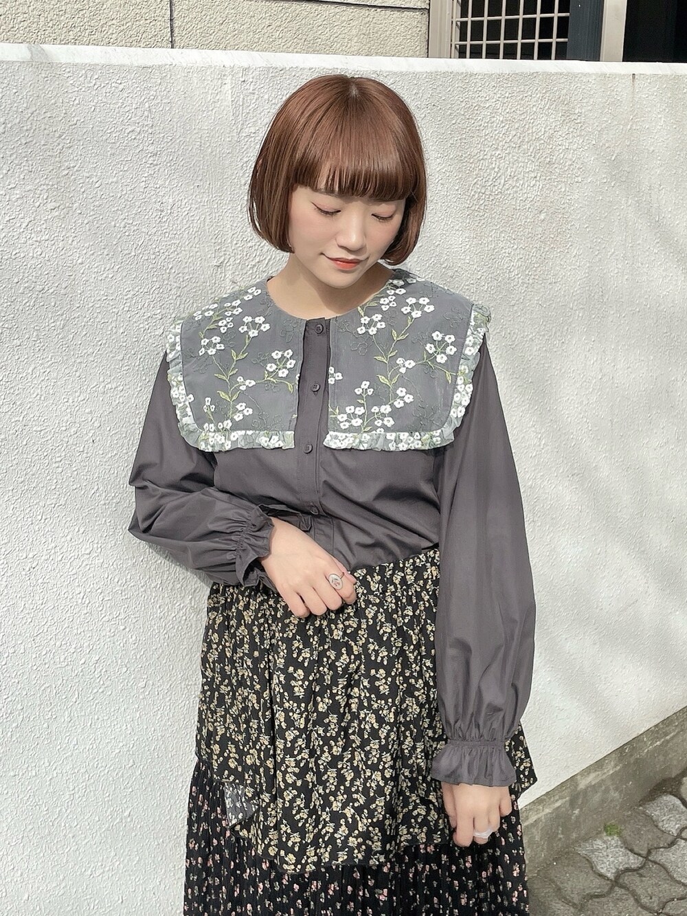 ピンク系のチェスターコート、ブラック系のスカート、グレー系のシャツ/ブラウスを着用したレディースの冬コーディネートの8枚目の写真