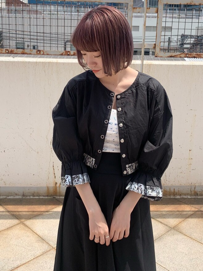 ブラック系のシャツ/ブラウス、ブラック系のスカート、ホワイト系のその他シューズを着用したレディースの春コーディネートの7枚目の写真