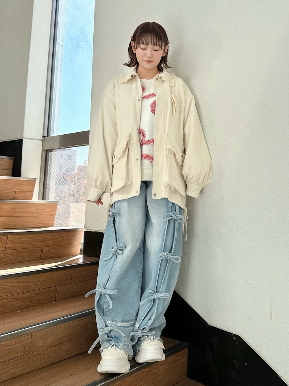 ホワイト系のブルゾン、ホワイト系のスウェット、ブルー系のデニムパンツを着用したレディースの冬コーディネートの2枚目の写真