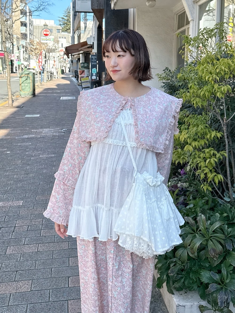 ピンク系のワンピース、ホワイト系のショルダーバッグ、ホワイト系のチュニックを着用したレディースの冬コーディネートの4枚目の写真