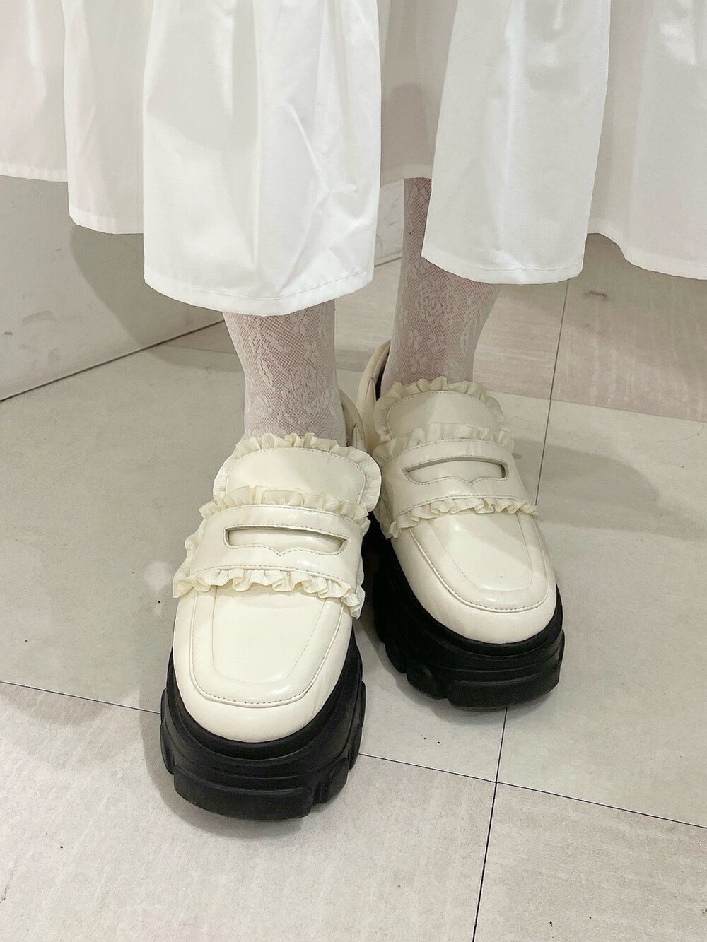 ホワイト系のワンピース、レッド系のカーディガン/ボレロ、ホワイト系のローファーを着用したレディースの秋コーディネートの7枚目の写真