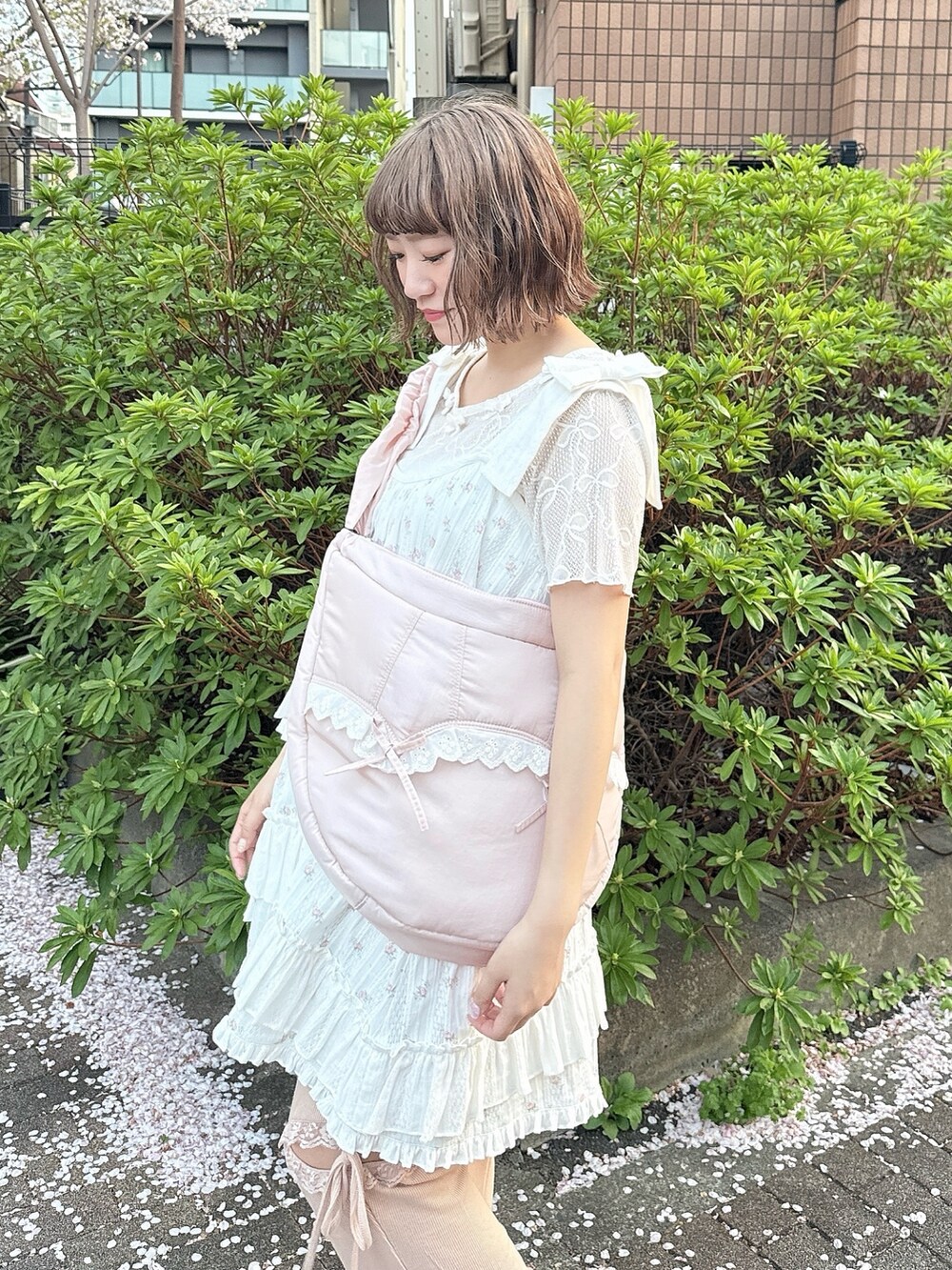 ピンク系のショルダーバッグ、ホワイト系のTシャツ/カットソー、ピンク系のワンピースを着用したレディースの春コーディネートの6枚目の写真