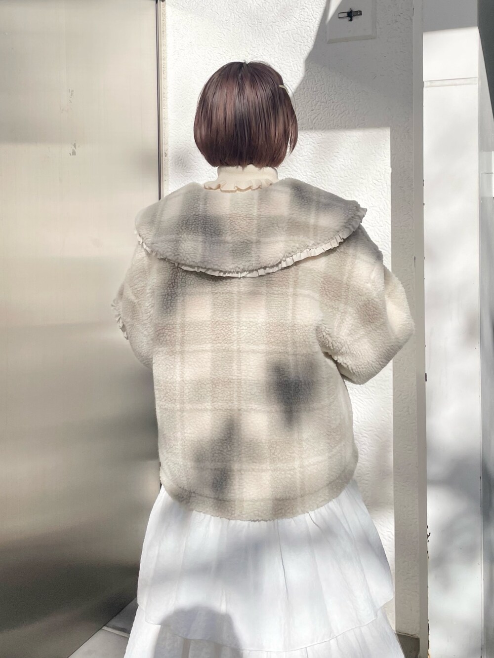 ホワイト系のスカート、ベージュ系のブルゾン、ホワイト系のニット/セーターを着用したレディースの冬コーディネートの6枚目の写真