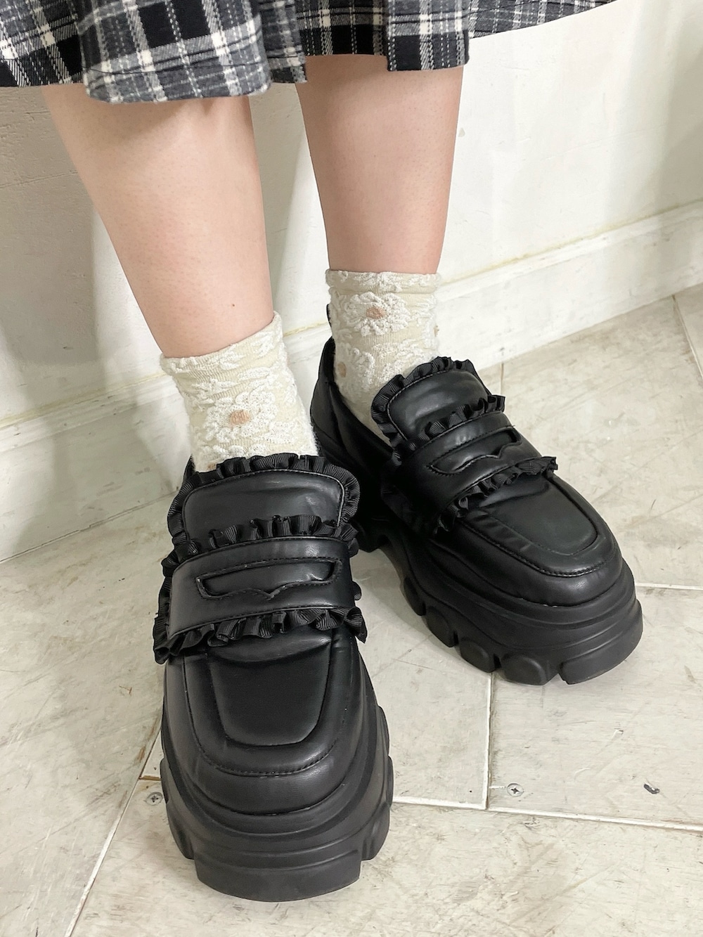 ブラック系のカーディガン/ボレロ、ブラック系のスカート、ブラック系のローファーを着用したレディースの秋コーディネートの6枚目の写真