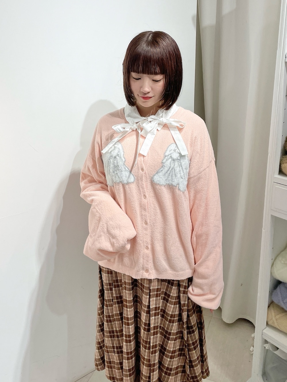 ホワイト系のシャツ/ブラウス、ピンク系のカーディガン/ボレロ、ブラウン系のスカートを着用したレディースの秋コーディネートの5枚目の写真