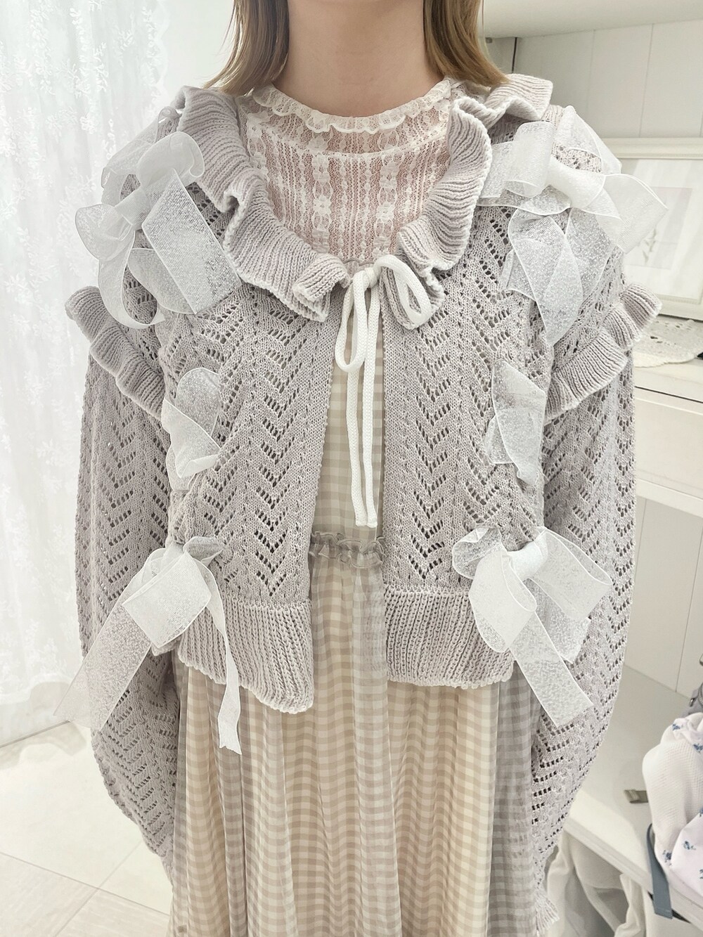 ホワイト系のTシャツ/カットソー、グレー系のカーディガン/ボレロ、グレー系のワンピースを着用したレディースの冬コーディネートの5枚目の写真
