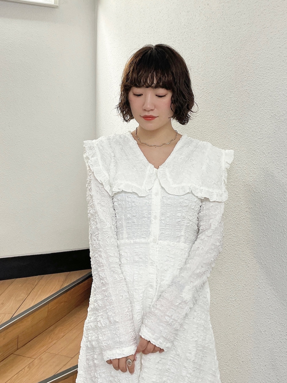 ホワイト系のワンピース、ベージュ系のブーツを着用したレディースの秋コーディネートの4枚目の写真