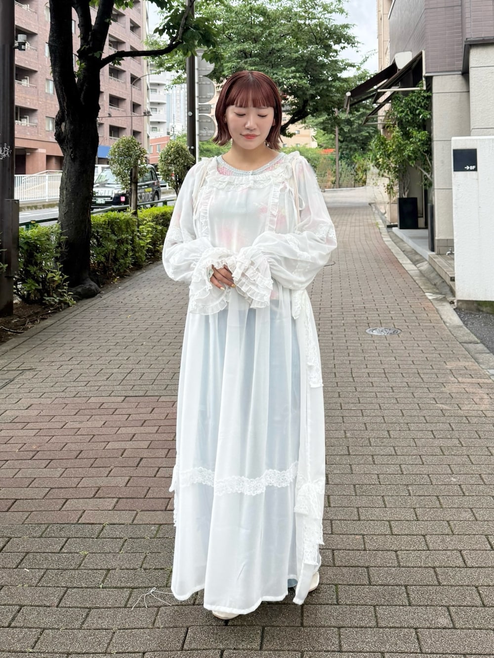 グリーン系のTシャツ/カットソー、ホワイト系のワンピース、ブルー系のデニムパンツを着用したレディースの夏コーディネートの2枚目の写真