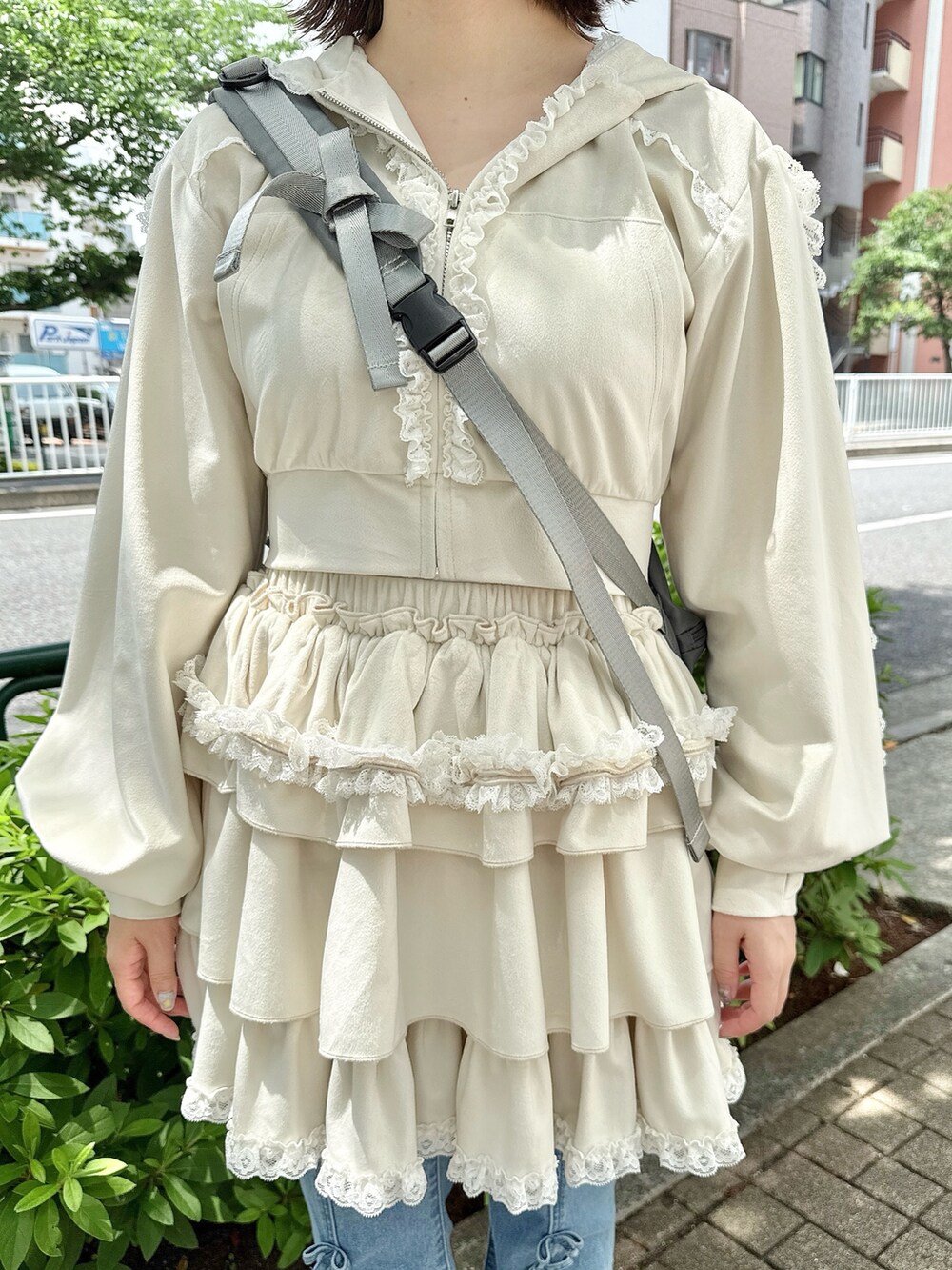ブルー系のデニムパンツ、ホワイト系のスカート、ホワイト系のパーカーを着用したレディースの春コーディネートの6枚目の写真