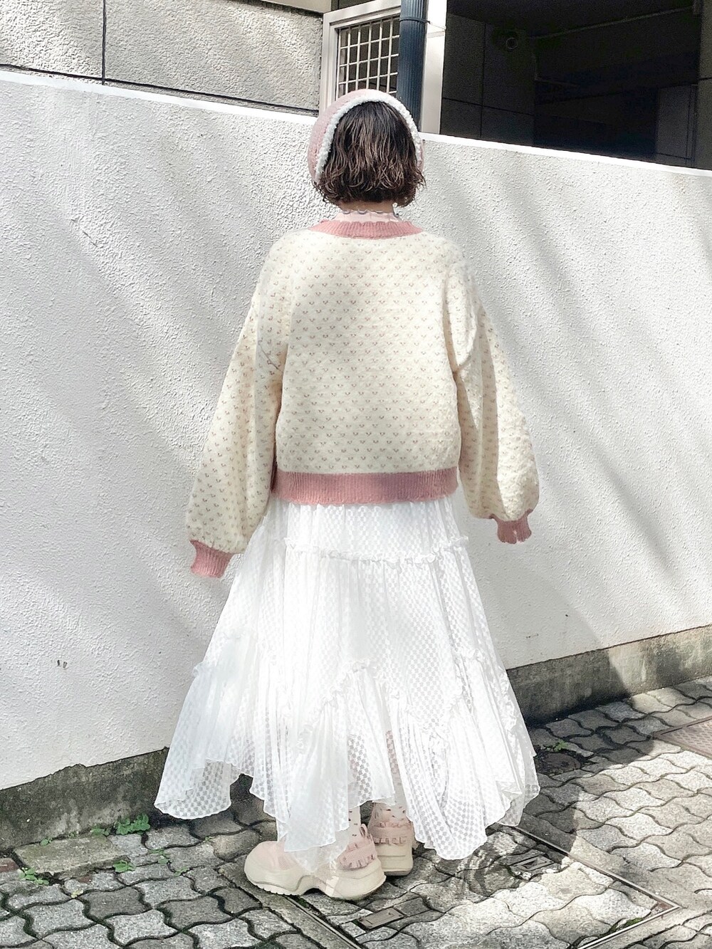 ピンク系のカーディガン/ボレロ、ピンク系のニット/セーター、ホワイト系のワンピースを着用したレディースの秋コーディネートの3枚目の写真