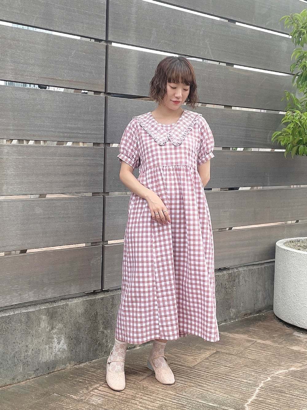 ピンク系のワンピース、ホワイト系のトートバッグ、ピンク系のパンプスを着用したレディースの夏コーディネートの3枚目の写真