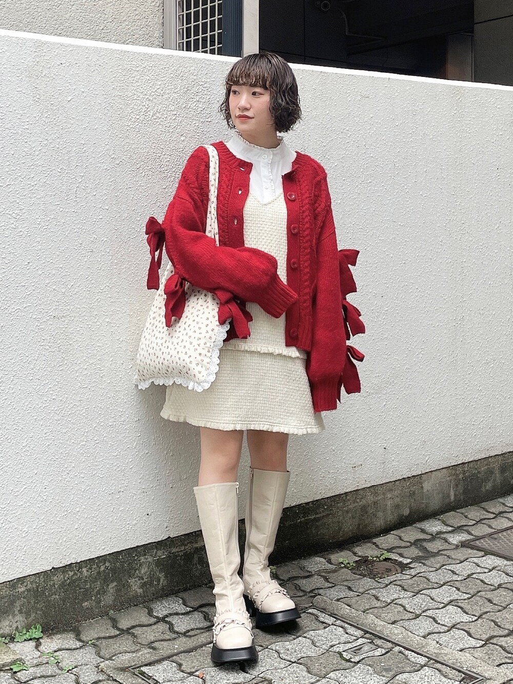 ホワイト系のシャツ/ブラウス、レッド系のカーディガン/ボレロ、ホワイト系のジャンパースカートを着用したレディースの秋コーディネートの2枚目の写真