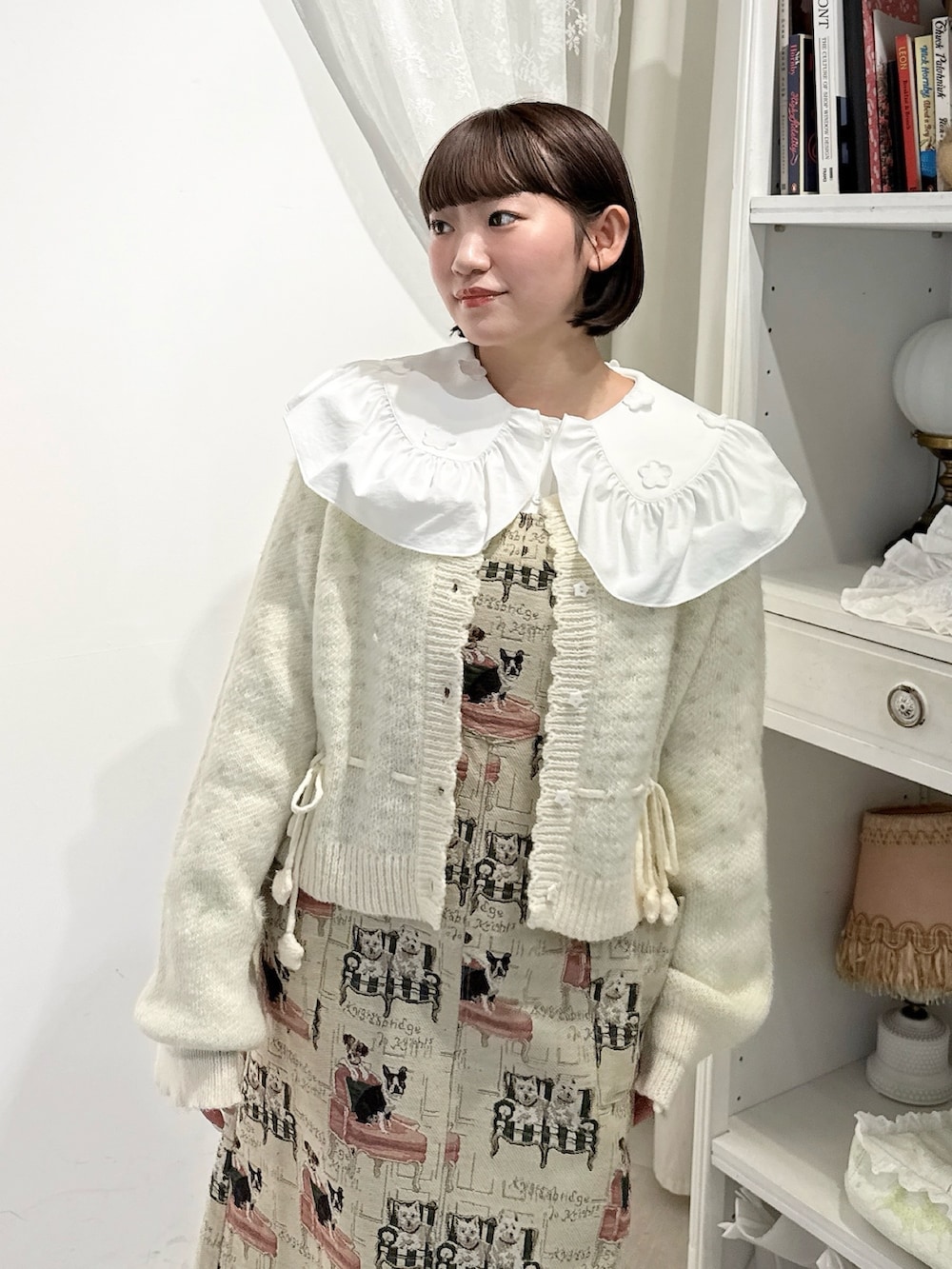 ベージュ系のジャンパースカート、ホワイト系のシャツ/ブラウス、ホワイト系のカーディガン/ボレロを着用したレディースの夏コーディネートの5枚目の写真