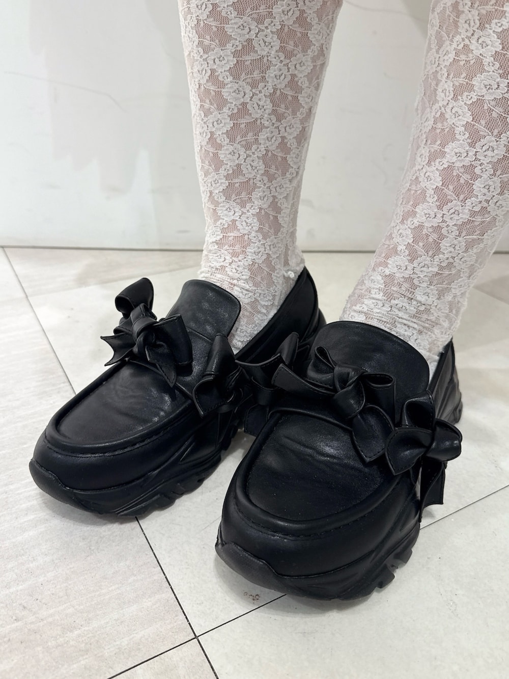 レッド系のニット/セーター、グレー系のワンピース、ブラック系のテーラードジャケットを着用したレディースの冬コーディネートの5枚目の写真