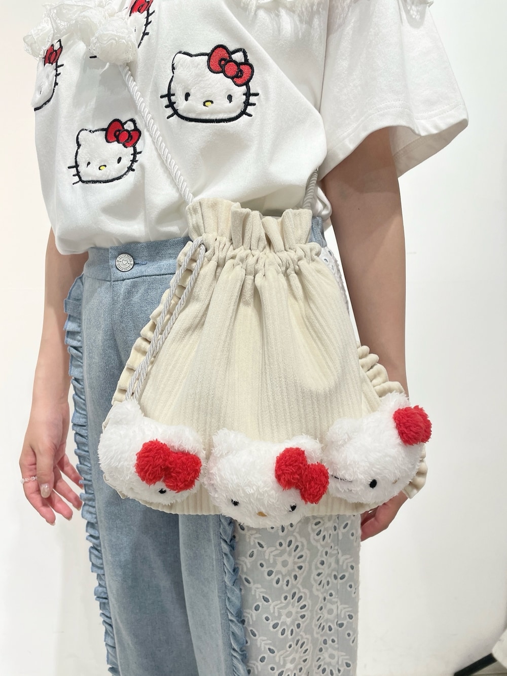 ブルー系のデニムパンツ、ホワイト系のスニーカー、ホワイト系のショルダーバッグを着用したレディースの春コーディネートの7枚目の写真
