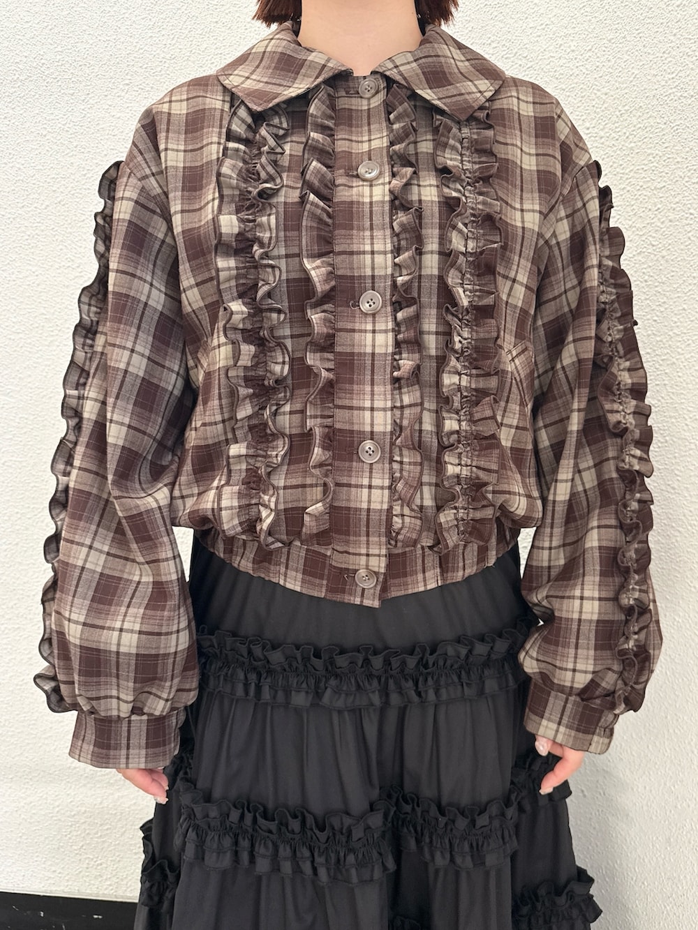 ブラウン系のブルゾン、ブラック系のスカート、ブラウン系のハンドバッグを着用したレディースの夏コーディネートの6枚目の写真