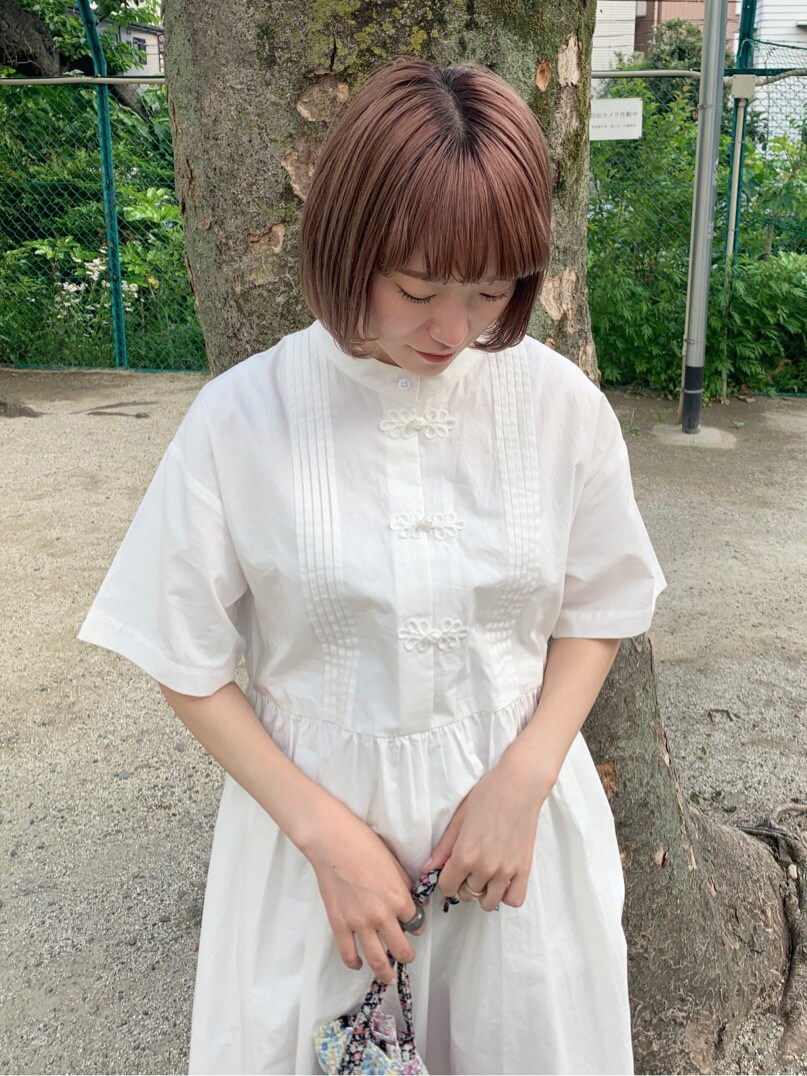 ピンク系のハンドバッグ、ホワイト系のワンピース、ピンク系のスニーカーを着用したレディースの春コーディネートの4枚目の写真