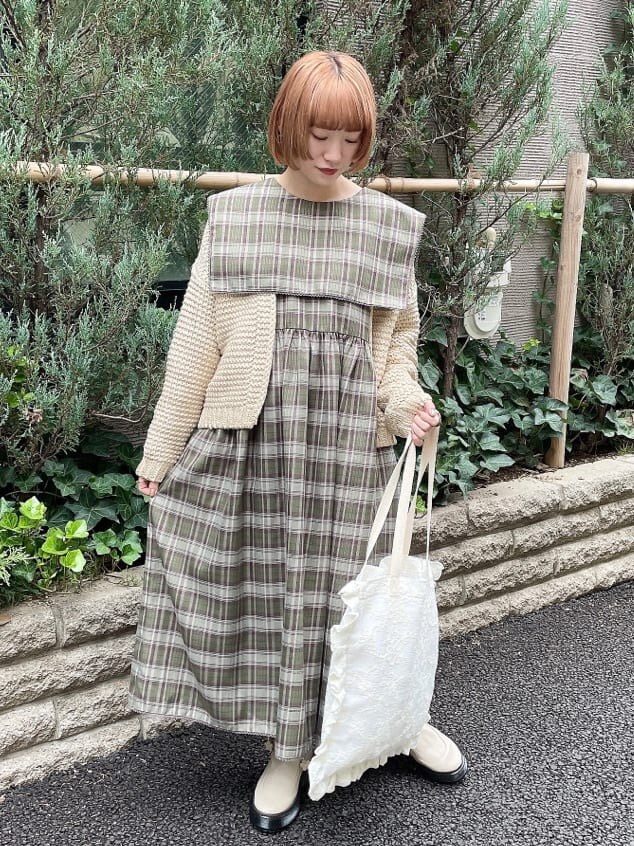 ホワイト系のブーツ、ゴールド系のカーディガン/ボレロ、グリーン系のワンピースを着用したレディースの秋コーディネートの2枚目の写真