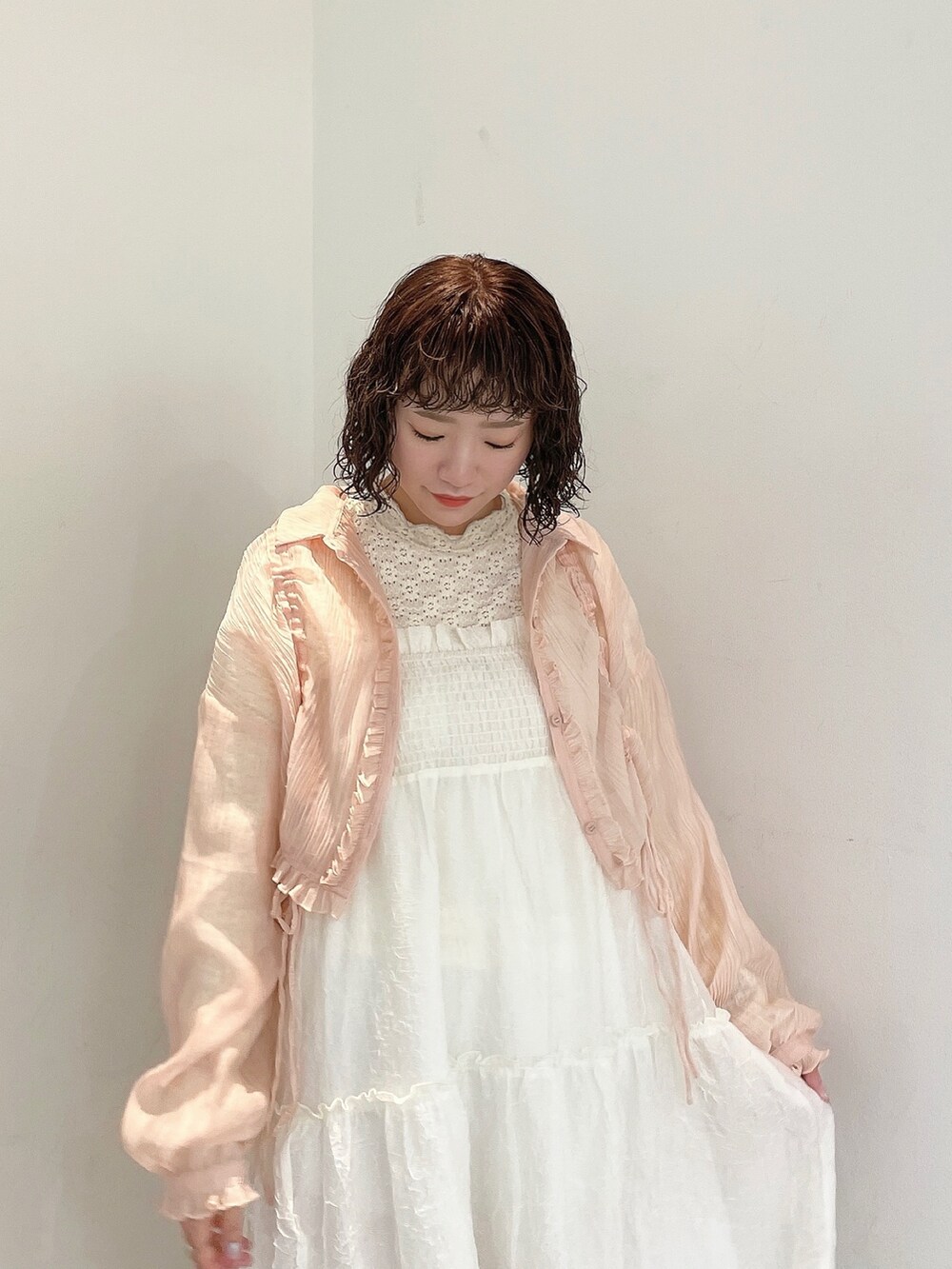 ホワイト系のワンピース、ピンク系のシャツ/ブラウス、ゴールド系のパンプスを着用したレディースの春コーディネートの5枚目の写真