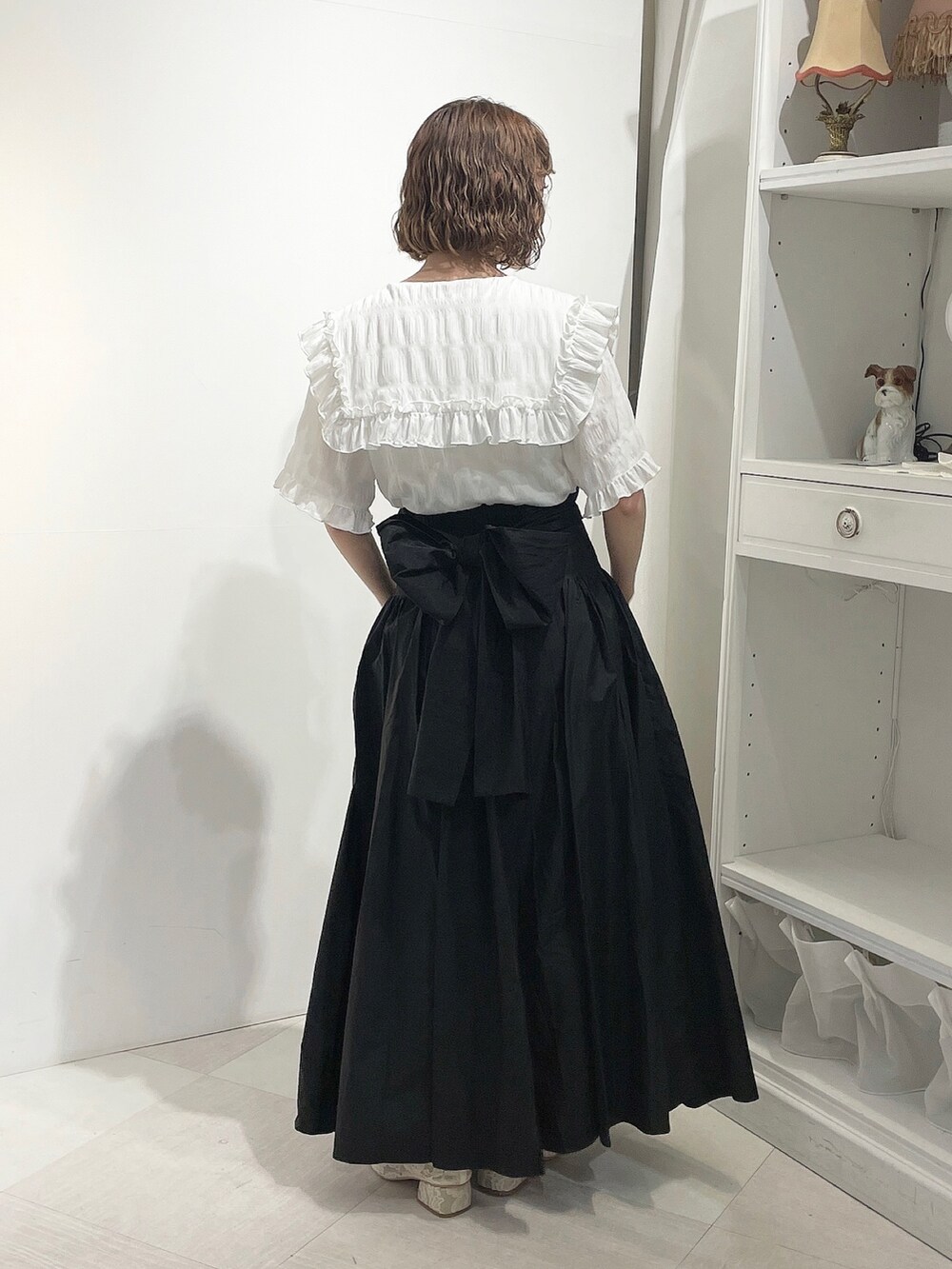 ホワイト系のシャツ/ブラウス、ブラック系のスカート、ホワイト系のパンプスを着用したレディースの春コーディネートの3枚目の写真