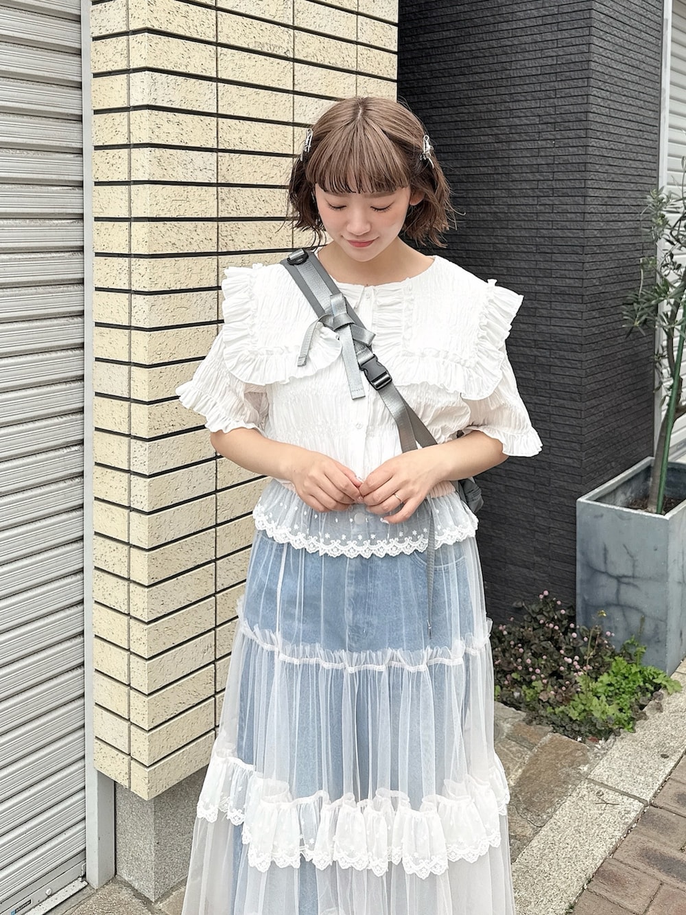 グレー系のショルダーバッグ、ホワイト系のシャツ/ブラウス、ピンク系のスカートを着用したレディースの春コーディネートの5枚目の写真