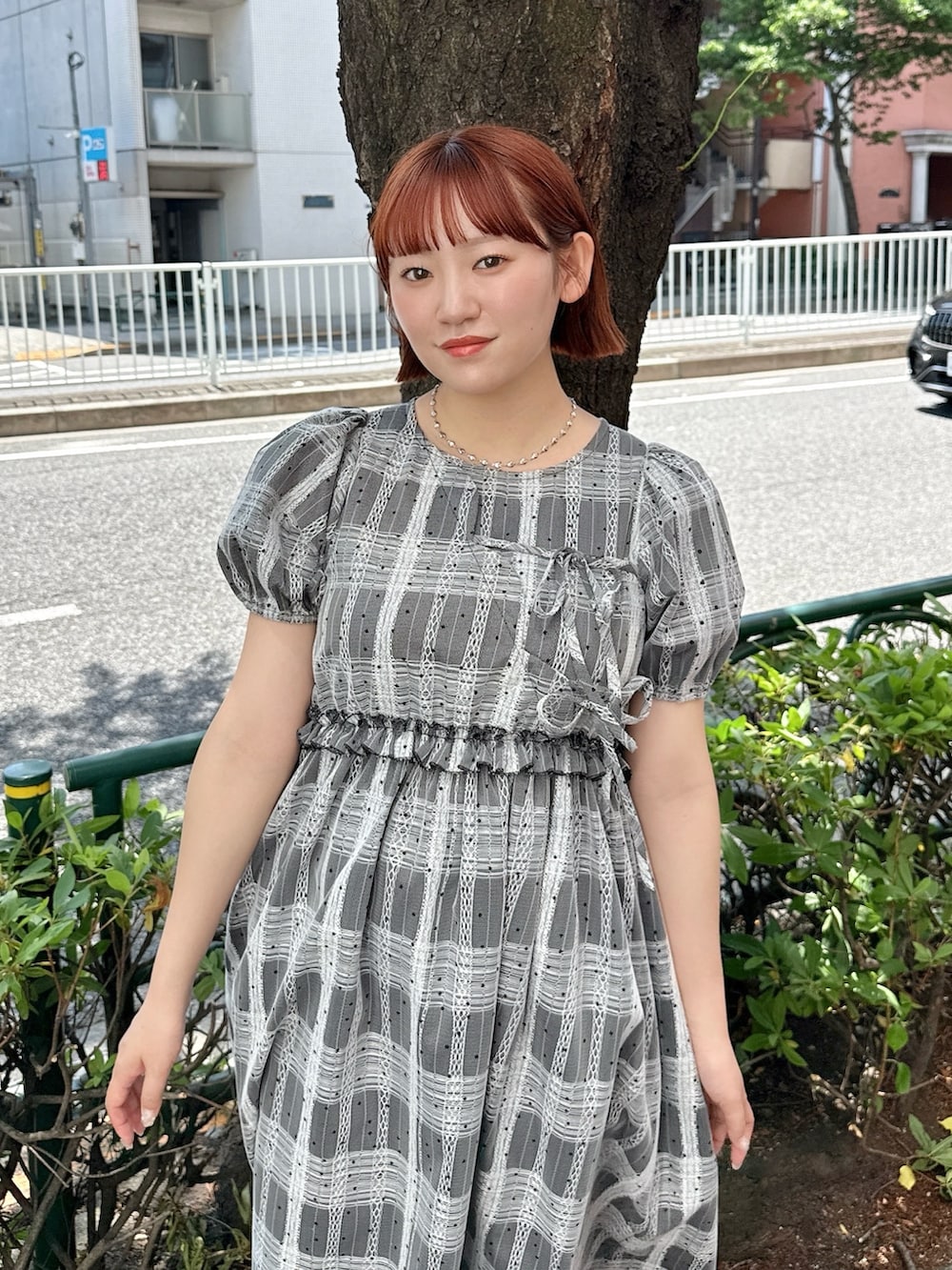 ブラック系のワンピース、レッド系のハンドバッグ、ブラック系のブーツを着用したレディースの夏コーディネートの4枚目の写真
