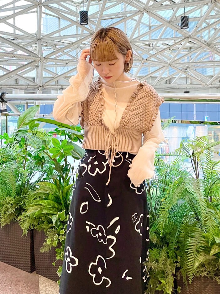 ベージュ系のニット/セーター、ホワイト系のチュニック、ブラック系のスカートを着用したレディースの夏コーディネートの4枚目の写真