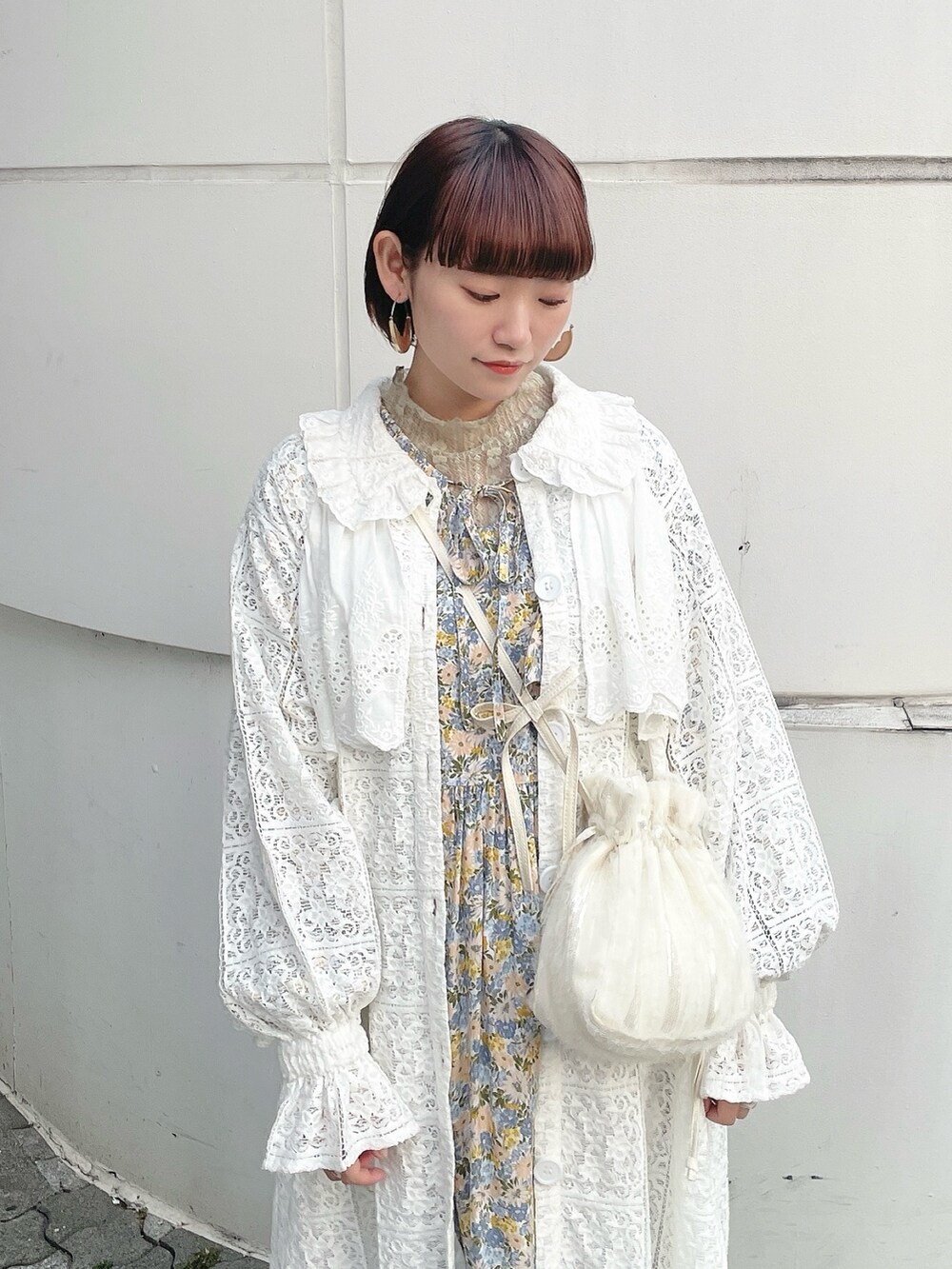 ホワイト系のトレンチコート、グリーン系のTシャツ/カットソー、イエロー系のワンピースを着用したレディースの冬コーディネートの4枚目の写真