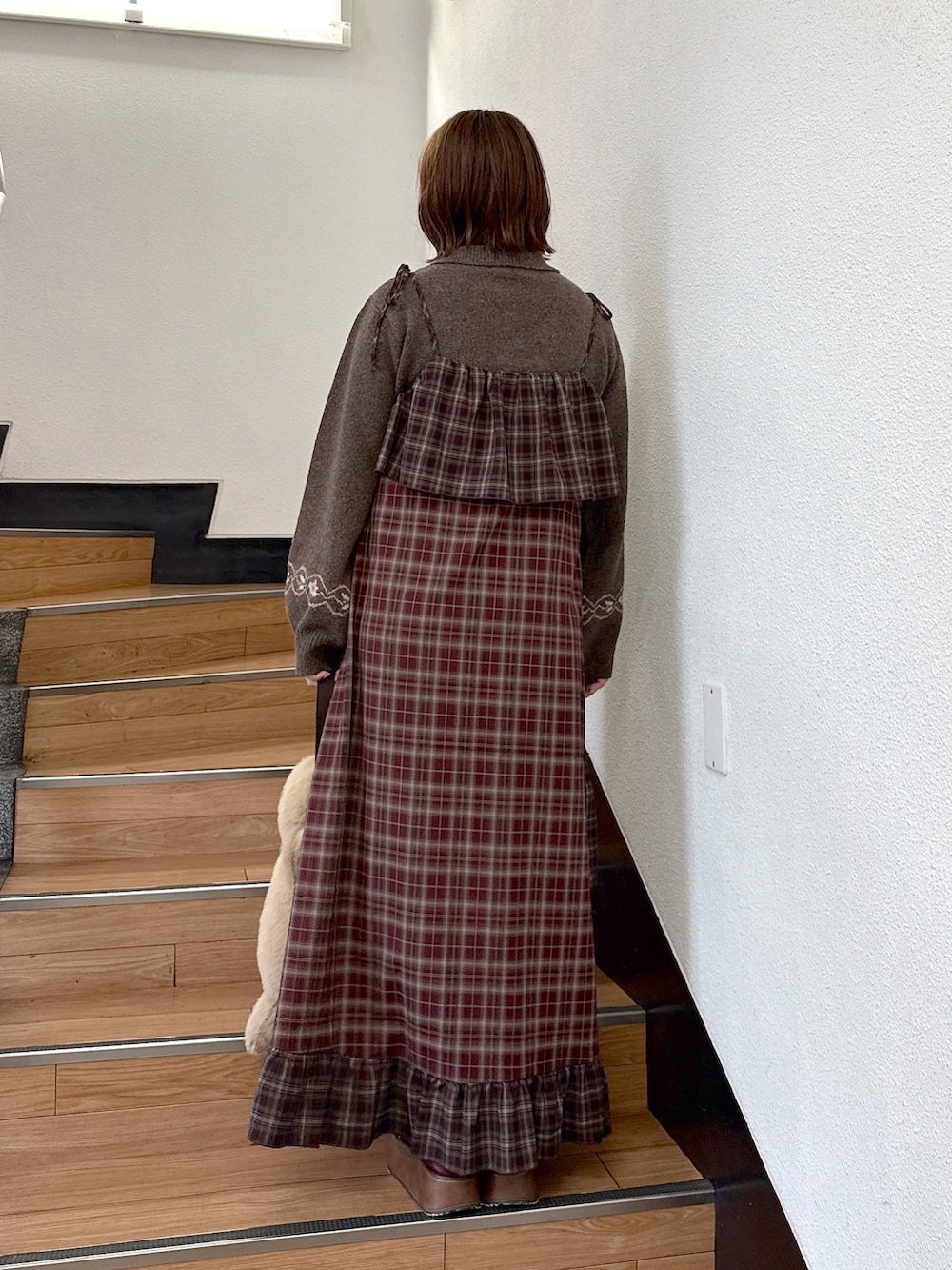 ブラウン系のニット/セーター、レッド系のワンピース、ベージュ系のハンドバッグを着用したレディースの秋コーディネートの4枚目の写真