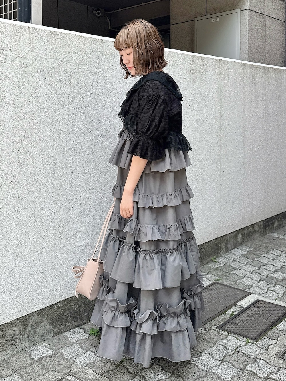 グレー系のワンピース、ブラック系のカーディガン/ボレロ、ピンク系のハンドバッグを着用したレディースの春コーディネートの4枚目の写真