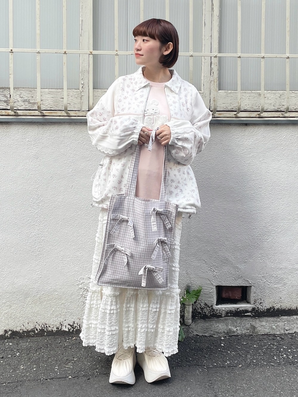 ピンク系のジャージ、ベージュ系のトートバッグ、ピンク系のスウェットを着用したレディースの冬コーディネートの3枚目の写真