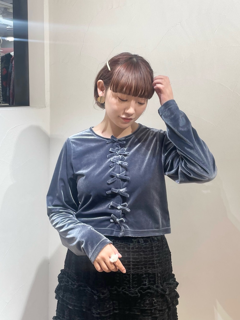 ブラック系のスカート、ブルー系のカーディガン/ボレロ、ブラック系のブーツを着用したレディースの冬コーディネートの4枚目の写真