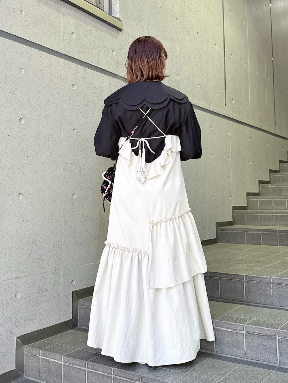 ベージュ系のワンピース、ブラック系のシャツ/ブラウス、ブラック系のショルダーバッグを着用したレディースの冬コーディネートの2枚目の写真