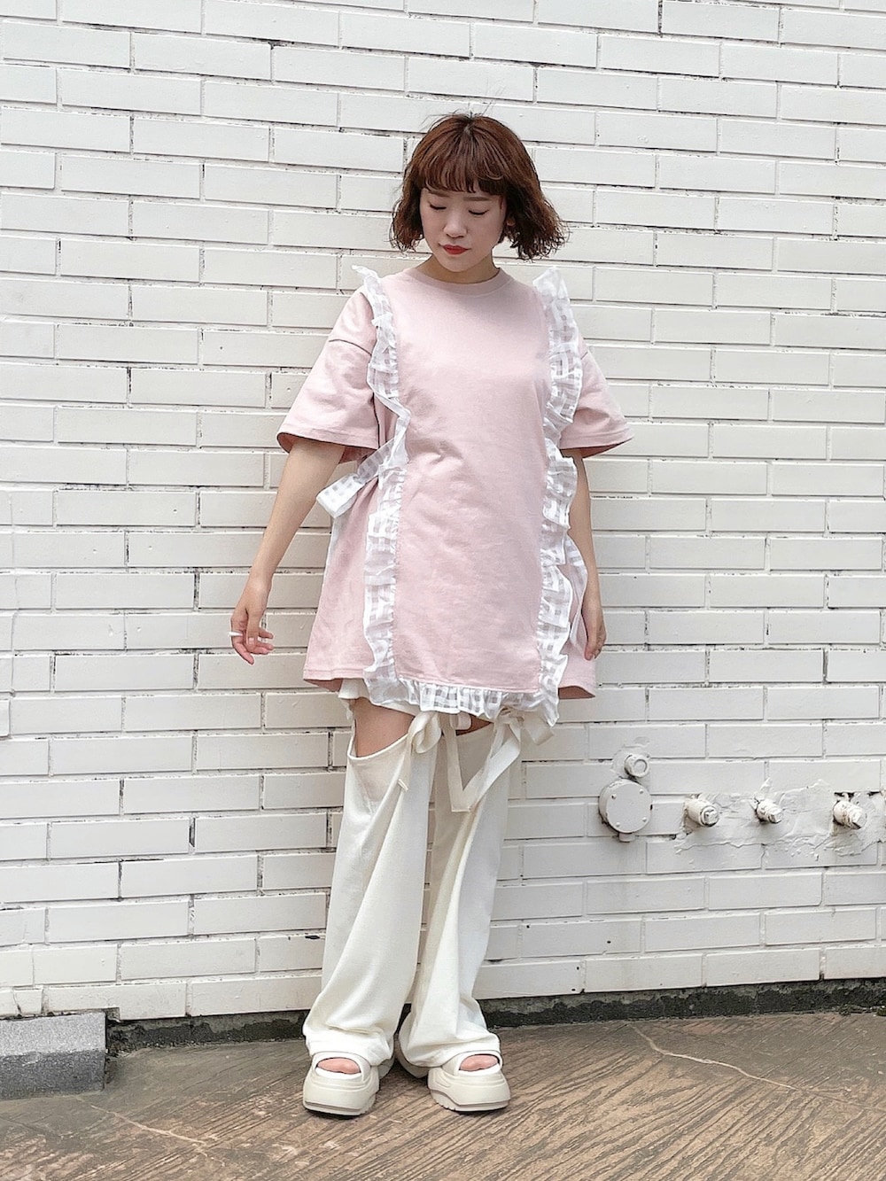 ピンク系のTシャツ/カットソー、ホワイト系のその他パンツ、ホワイト系のサンダルを着用したレディースの春コーディネートの3枚目の写真