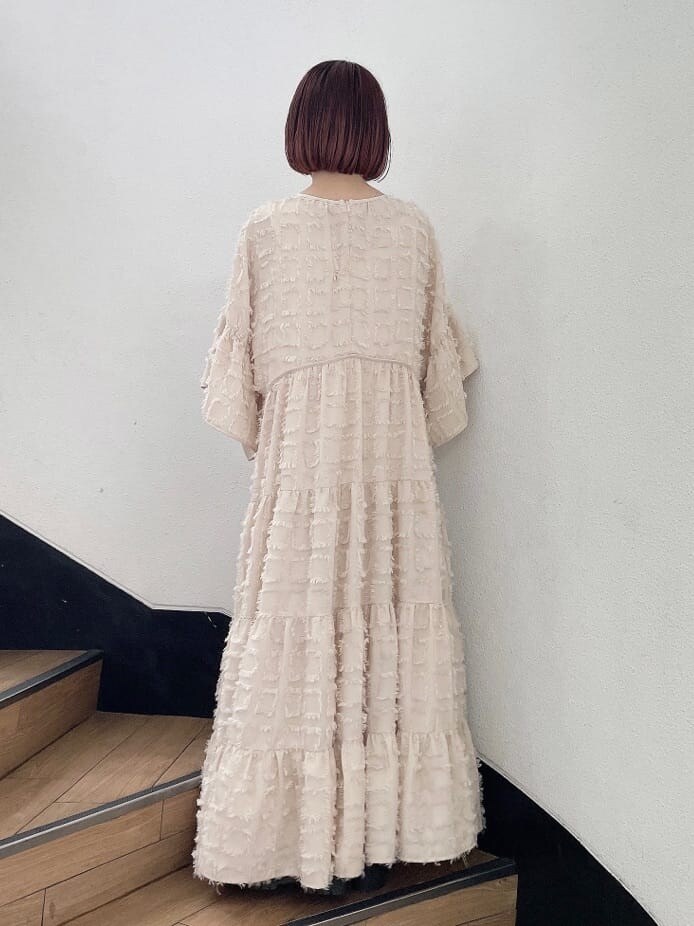 ベージュ系のドレス、グリーン系のハンドバッグ、ベージュ系のブーツを着用したレディースの夏コーディネートの4枚目の写真