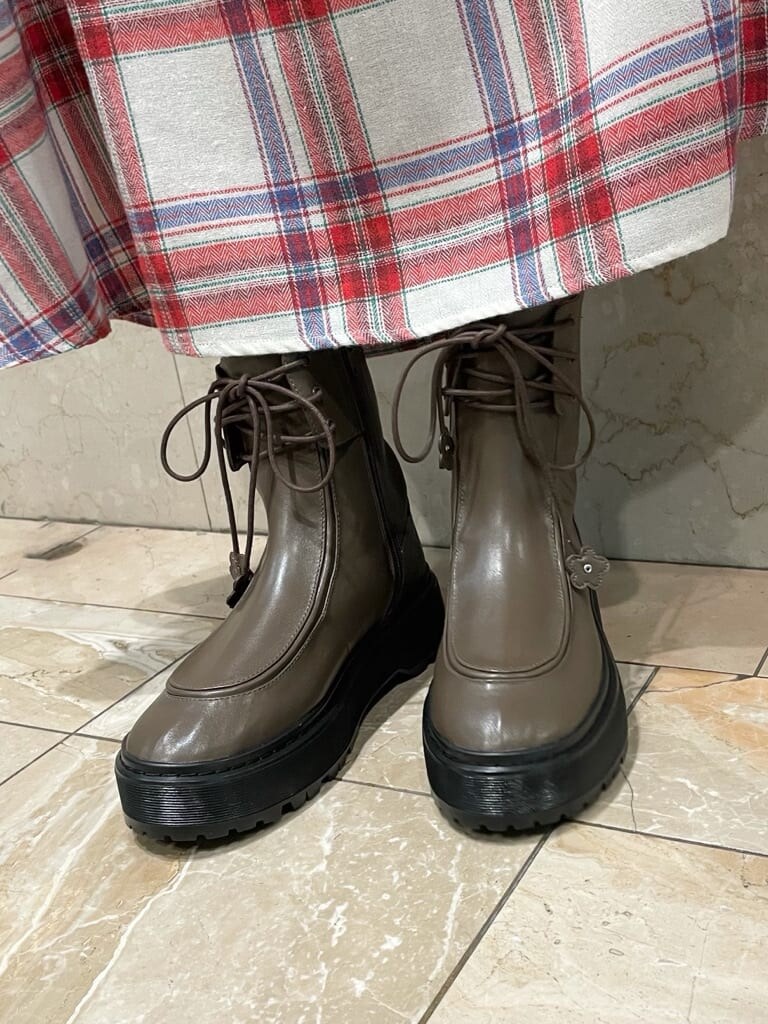 ブラウン系のブーツ、ブラウン系のカーディガン/ボレロ、レッド系のスカートを着用したレディースの秋コーディネートの5枚目の写真