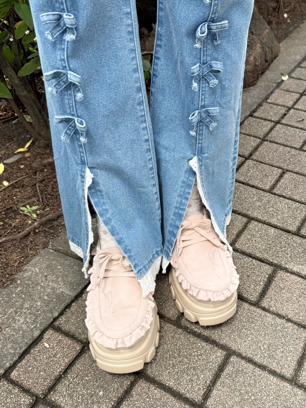 ホワイト系のテーラードジャケット、ブルー系のデニムパンツ、ホワイト系のショルダーバッグを着用したレディースの夏コーディネートの8枚目の写真