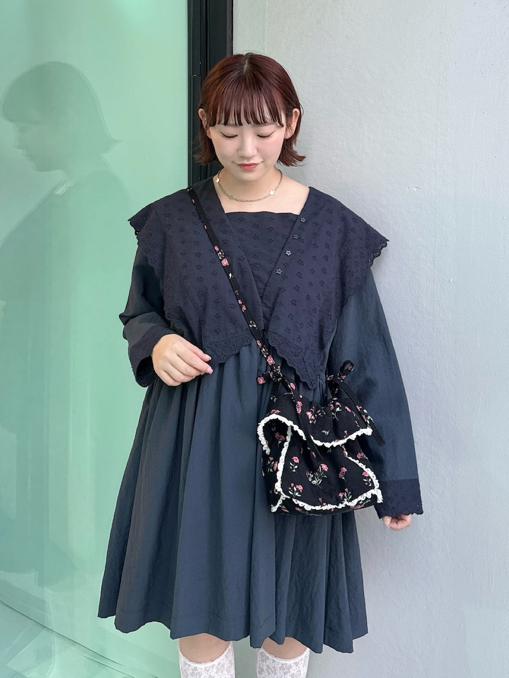 ブルー系のワンピース、ブラック系のショルダーバッグ、ブラック系のスニーカーを着用したレディースの冬コーディネートの4枚目の写真